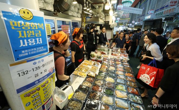 [인천=뉴시스] 고범준 기자 = 이재명 대통령 부인 김혜경 여사가 25일 인천 계양산전통시장을 찾아 민생회복 소비쿠폰을 이용해 음식을 구매한 뒤 상인과 인사하고 있다. 2025.07.25. bjko@newsis.com /사진=고범준