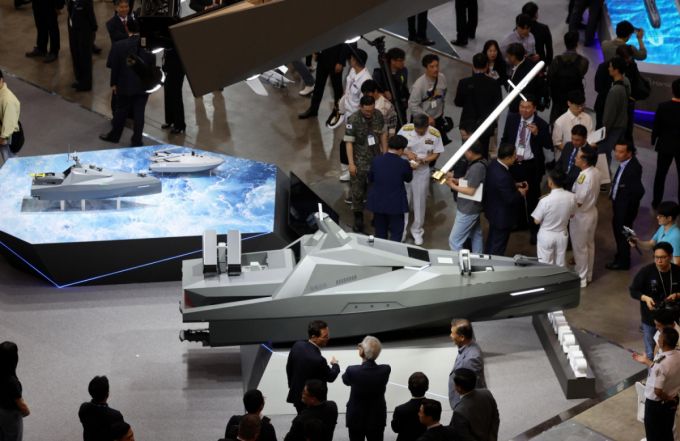 지난 5월 '국제해양방위산업전 2025(MADEX)'가 열린 부산 해운대구 벡스코 제1전시장을 찾은 관람객들이 LIG넥스원 부스에서 최초로 공개한 전투용 무인잠수정 콘셉트 모델 '해검-X'를 살펴보고 있다./사진=뉴시스 /사진=하경민