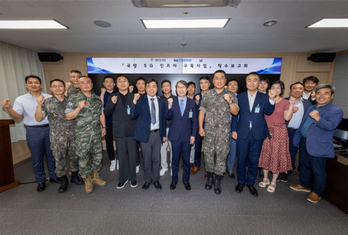 KT Enterprise부문 이행1본부장 이진권 상무(앞줄 왼쪽부터 6번째)와 국방부, 한국지능정보사회진흥원(NIA) 주요 관계자가 ‘국방 5G 인프라 구축’ 사업 착수보고회에서 단체 기념사진을 촬영하는 모습. /사진=KT