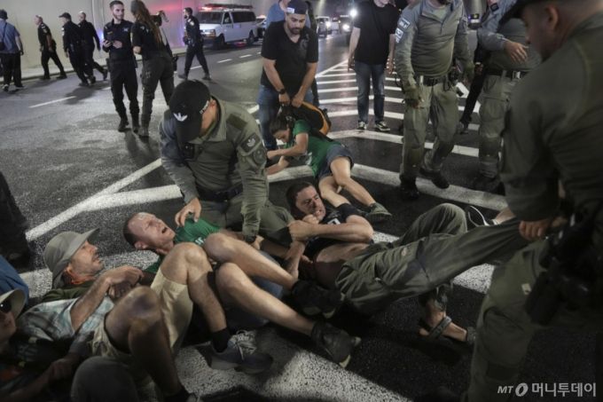 [예루살렘=AP/뉴시스] 17일(현지 시간) 예루살렘 인근에서 이스라엘 경찰이 도로를 막고 농성 중인 시위대를 해산시키고 있다. 시위대는 정부의 가자지구 점령 결정 철회와 하마스에 억류된 인질들의 즉각적인 석방을 요구하며 시위를 벌였다. 2025.08.18. /사진=민경찬