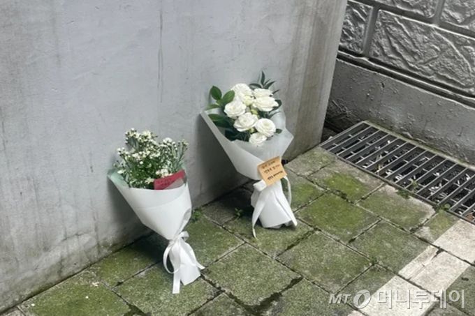 세모녀 추락사 사건이 발생한 서울 강서구의 한 오피스텔 건물 앞 주민들이 두고 간 추모꽃들이 놓여있다./사진=이현수 기자