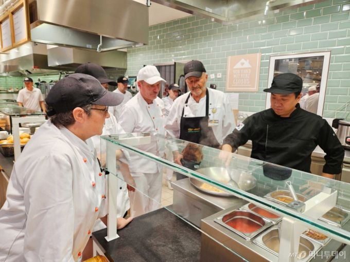 [서울=뉴시스] 더본코리아가 독일의 대형 유통그룹 글로버스 본사가 위치한 상트벤델 지역의 마크탈레 하이퍼마켓 푸드코트에서 더본코리아의 ‘글로벌 푸드 컨설팅 프랜차이즈’ 방식을 도입한 ‘비빔밥 및 덮밥’ 메뉴를 정식 론칭했다고 10일 밝혔다. 사진은 독일 글로버스 현지 조리사들에게 더본코리아가 컨설팅하는 모습. (사진=더본코리아 제공) 2025.07.10. photo@newsis.com *재판매 및 DB 금지 /사진=