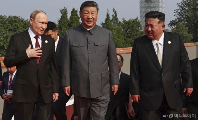 김정은 북한 국무위원장이 3일(현지시간) 시진핑 중국 국가주석, 블라디미르 푸틴 러시아 대통령과 얘기하며 '중국 인민 항일 전쟁 및 세계 반파시스트 전쟁 승리(전승절)' 80주년 기념 열병식이 열리는 베이징 톈안먼광장에 도착하고 있다. / AP=뉴시스
