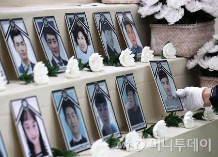 코로나19백신피해자가족협의회 관계자들이 18일 오전 서울 중구 청계광장에 마련된 '코로나19 백신 희생자 합동 분향소'를 자진 철거하며 고인의 영정을 정리하고 있다./사진=(서울=뉴스1) 오대일 기자