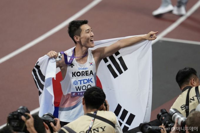 [도쿄=AP/뉴시스] 우상혁이 16일 일본 도쿄 국립경기장에서 열린 2025 도쿄 세계육상선수권대회 남자 높이뛰기 결선에서 2ｍ34로 은메달을 획득한 뒤 메달을 목에 걸고 기뻐하고 있다. 2025.09.16. /사진=김진아