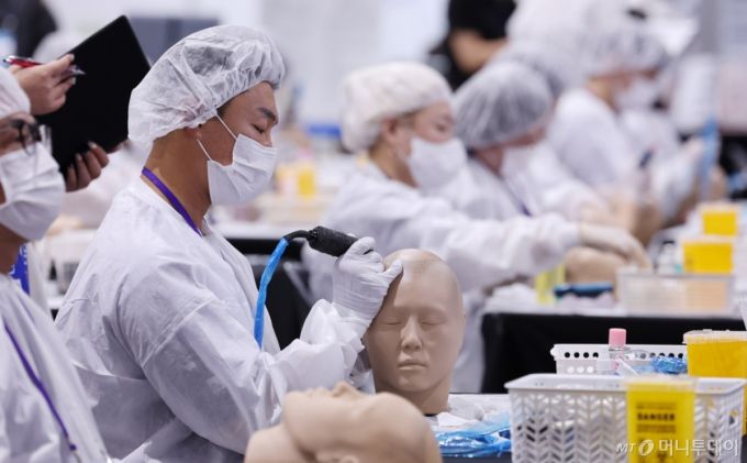 지난 15일 서울 강남구 SETEC 1전시장에서 열린 국내 최초 문신산업박람회 ‘PTS문화예술대전'에서 문신 경연 참가자들이 개성 넘치는 작품을 선보이고 있다./사진= 뉴스1