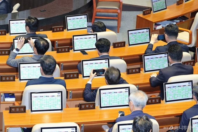 (서울=뉴스1) 신웅수 기자 = 26일 서울 여의도 국회에서 열린 제429회국회(정기회) 9차 본회의에서 검찰청 폐지를 골자로 한 정부조직법 개정안이 통과되자 의원들이 스마트폰으로 사진을 남기고 있다.  검찰청 폐지를 골자로 한 정부조직법 개정안이 국회를 통과하면서 1948년 8월 정부 수립과 함께 설치된 검찰청은 78년 만에 간판을 내리게 된다. 2025.9.26/뉴스1  Copyright (C) 뉴스1. All rights reserved. 무단 전재 및 재배포,  AI학습 이용 금지. /사진=(서울=뉴스1) 신웅수 기자