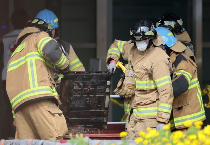 (대전=뉴스1) 김진환 기자 = 27일 오후 대전 유성구 국가정보자원관리원 화재현장에서 소방당국 관계자들이 소실된 리튬이온배터리에 대한 반출 작업을 하고 있다.   전산 자원을 통합 관리하는 행정안전부 산하 국가정보자원관리원에서 지난 26일 오후 배터리 교체 작업 중 화재가 발생, 정부 온라인 서비스 70개가 마비됐다. 2025.9.27/뉴스1