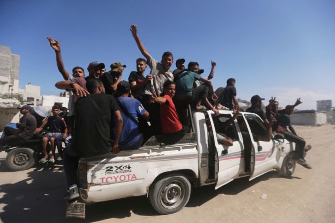 이스라엘과 하마스가 1단계 휴전에 합의한 가운데 10일(현지 시간) 팔레스타인 피란민들이 가자지구 와디가자에서 가자시티로 돌아가는 차량에 탑승해 카메라를 향해 손을 흔들고 있다. /AP=뉴시스