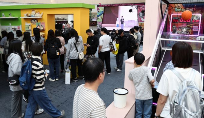 19일 오후 서울 송파구 롯데월드 아이스링크에 마련된 '2025 월드 웹툰 페스티벌' 행사장에서 관람객들이 웹툰 전시를 둘러보고 있다.  / 사진 = 뉴스1