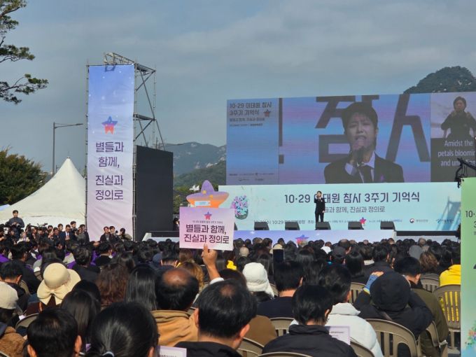29일 오전 서울 종로구 광화문 광장에서 이태원 참사 3주기 기억식 무대가 진행되는 모습. 가수 안예은의 노래가 이어지던 중 한 시민이 플래카드를 높이 들어올리며 추모의 뜻을 전했다./사진=김서현 기자.