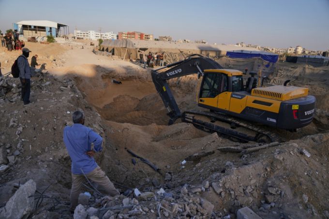 팔레스타인 주민들이 27일(현지 시간) 가자지구 남부 칸유니스의 하마드 시티에서 이집트인들이 중장비로 이스라엘 인질 시신을 수색하는 모습을 지켜보고 있다. /AP=뉴시스