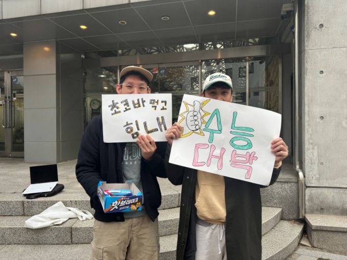 13일 오전 서울 종로구 경복고등학교 앞에서 만난 황모씨. 황씨는 캐나다 국적 지인과 함께 수능현장을 찾아 수험생을 응원했다./사진=최문혁 기자.