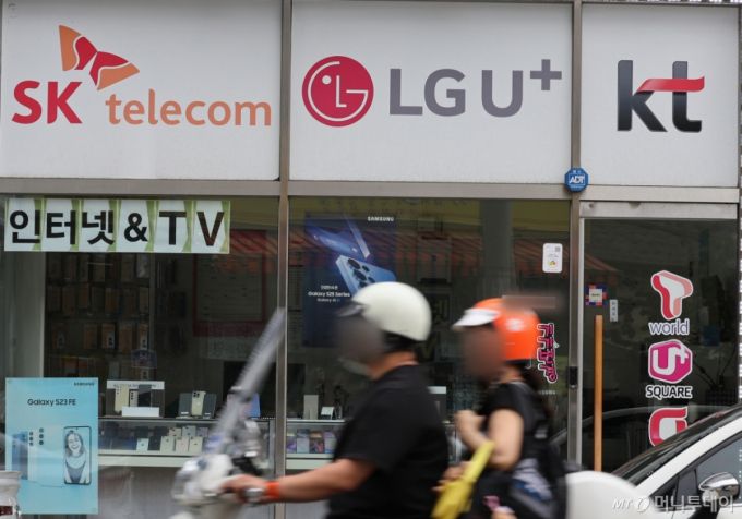 [서울=뉴시스] 배훈식 기자 = SK텔레콤 사이버 침해 사고 위약금 면제 기한이 하루 앞으로 다가온 13일 서울 서대문구의 한 휴대전화 판매점에 이동통신 3사 로고가 붙어 있다. 이번 사고로 촉발된 이통 3사간의 고객유치전이 막바지로 치달으며 보조금 경쟁 등 과열양상을 띄고 있다. 2025.07.13.  /사진=배훈식