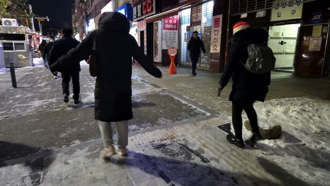 5일 오전 시민들이 경기도 안양시 인덕원역 인근으로 이동하는 모습. 한 시민이 양 팔을 벌리며 중심을 잡으려는 모습./사진=김서현 기자.