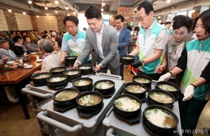 대구 중구의 한 음식점에서 열린 '초복맞이 영약식 나눔 데이' 행사에서 각 기관 봉사자들이 어르신에게 갈비탕을 전달하고 있다./사진제공=뉴스1
