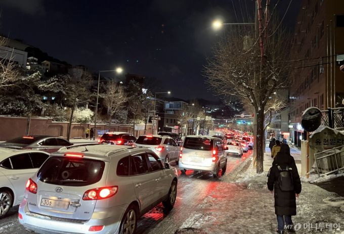 (서울=뉴스1) 황기선 기자 = 폭설이 내린 4일 오후 서울 종로구 자하문로에서 차량들이 눈길에 큰 정체를 빚자 시민들이 버스에서 내려 걸어가고 있다.2025.12.4/뉴스1  Copyright (C) 뉴스1. All rights reserved. 무단 전재 및 재배포,  AI학습 이용 금지. /사진=(서울=뉴스1) 황기선 기자