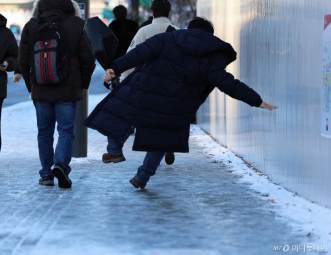 (서울=뉴스1) 구윤성 기자 = 폭설 후 한파로 도로 곳곳이 얼어붙은 5일 오전 서울 광화문역 일대에서 한 시민이 빙판길에 미끄러져 넘어지고 있다. 2025.12.5/뉴스1  Copyright (C) 뉴스1. All rights reserved. 무단 전재 및 재배포,  AI학습 이용 금지. /사진=(서울=뉴스1) 구윤성 기자