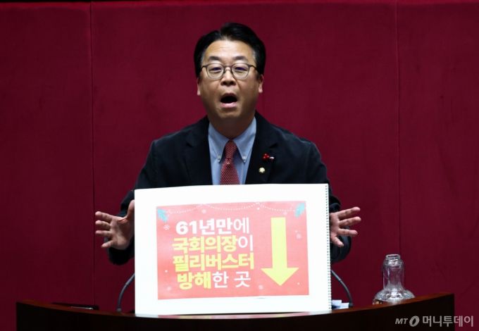 [서울=뉴시스] 김명년 기자 = 곽규택 국민의힘 의원이 11일 오후 서울 여의도 국회 본회의에서 형사소송법 일부개정법률안에 대한 필리버스터(무제한 토론)를 하고 있다. 곽 의원은 지난번 본회의에서 벌어진 나경원 의원 토론 중단사태에 대해 항의하는 내용이 적힌 손피켓을 들고 토론에 나섰다. 2025.12.11. kmn@newsis.com /사진=김명년