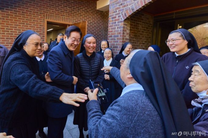 [서울=뉴시스] 최동준 기자 = 이재명 대통령이 25일 인천 계양구 노틀담 수녀원을 방문해 수녀들과 성탄 인사를 나누며 기념촬영을 하고 있다. (사진=대통령실 제공) 2025.12.25. photo@newsis.com *재판매 및 DB 금지 /사진=