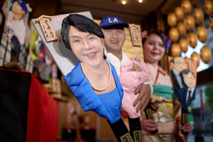 12월 3일 일본 도쿄의 전통 인형 제작업체 규게쓰에서 이곳 직원이 2025년 하고이타 나무 채를 들고 포즈를 취하고 있다. 나무 채에는 최근 대만 발언으로 논란을 빚고 있는 다카이치 사나에 일본 총리와 미국 프로야구 LA 다저스의 오타니 쇼헤이가 디자인돼 있다. '하고이타'는 배드민턴 라켓 모양의 나무판으로 된 전통 놀이기구로 최근에는 올해의 인물들을 디자인해 새해 장식품 등으로 제작한다./AP=뉴시스