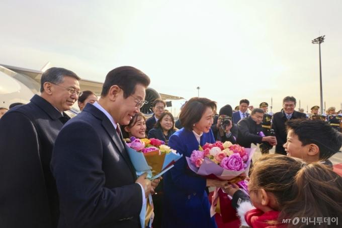 (베이징(중국)=뉴스1) 허경 기자 = 중국을 국빈방문하는 이재명 대통령과 김혜경 여사가 4일 베이징 서우두 공항에서 화동들에게 꽃다발을 전달 받고 있다. (공동취재) 2026.1.4/뉴스1  Copyright (C) 뉴스1. All rights reserved. 무단 전재 및 재배포,  AI학습 이용 금지. /사진=(베이징(중국)=뉴스1) 허경 기자