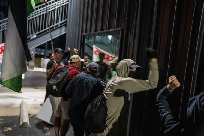 [플루거빌=AP/뉴시스] 8일(현지 시간) 미 텍사스주 플루거빌에서 전날 미네소타주 미니애폴리스에서 이민세관단속국(ICE) 요원의 총격으로 사망한 르네 니콜 굿 사건에 항의하는 시위대가 현지 ICE 시설 벽을 두드리며 철수를 요구하고 있다.