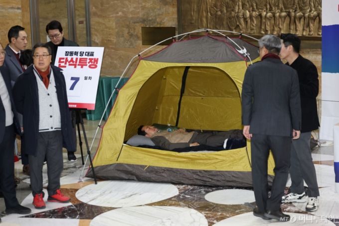 (서울=뉴스1) 이승배 기자 = 장동혁 국민의힘 대표가 21일 서울 여의도 국회 로텐더홀에서 더불어민주당의 통일교 및 공천뇌물 특검 수용을 촉구하며 7일째 단식을 이어가고 있다. 소방 구급대원들이 장 대표의 병원 이송을 위해 단식장에 출동했으나 이송 거부로 돌아갔다. 2026.1.21/뉴스1  Copyright (C) 뉴스1. All rights reserved. 무단 전재 및 재배포,  AI학습 이용 금지. /사진=(서울=뉴스1) 이승배 기자
