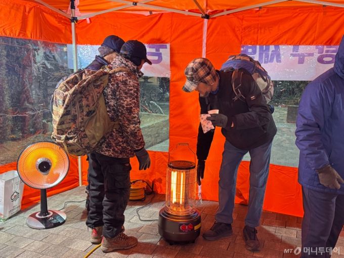 21일 새벽 5시쯤 서울 중랑구 면목역 광장 '새벽일자리 쉼터'에서 몸을 녹이는 건설 일용직 근로자들의 모습./사진=최문혁 기자.