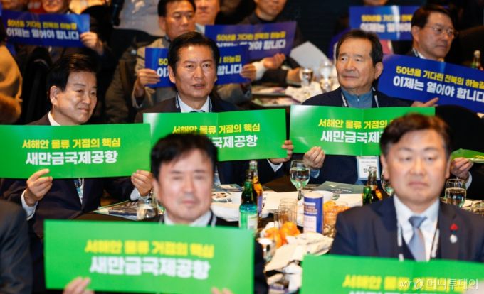 (서울=뉴스1) 안은나 기자 = 정동영 통일부 장관, 정청래 더불어민주당 대표, 정세균 노무현재단 이사장 등 참석자들이 8일 오후 서울 중구 더플라자호텔에서 열린 2026 전북특별자치도민회중앙회 신년인사회에 참석해 새만금국제공항 정상화 촉구 피켓을 들고 있다. 2026.1.8/뉴스1  Copyright (C) 뉴스1. All rights reserved. 무단 전재 및 재배포,  AI학습 이용 금지. /사진=(서울=뉴스1) 안은나 기자