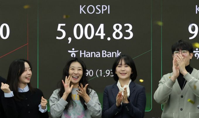 (서울=뉴스1) 박지혜 기자 = 22일 오전 서울 중구 하나은행 본점 딜링룸 현황판에 코스피 지수가 장중 5000p를 넘으며 개장하자 직원들이 환호하고 있다. 2026.1.22/뉴스1  Copyright (C) 뉴스1. All rights reserved. 무단 전재 및 재배포,  AI학습 이용 금지. /사진=(서울=뉴스1) 박지혜 기자
