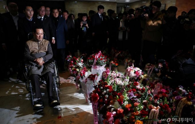 [서울=뉴시스] 김명년 기자 = 장동혁 국민의힘 대표가 22일 서울 여의도 국회에서 통일교·공천헌금 '쌍특검' 수용 촉구 단식을 마치고 병원 이송을 위해 휠체어를 타고 이동하며 지지자들이 준 꽃바구니를 바라보고 있다. 2026.01.22. kmn@newsis.com /사진=김명년