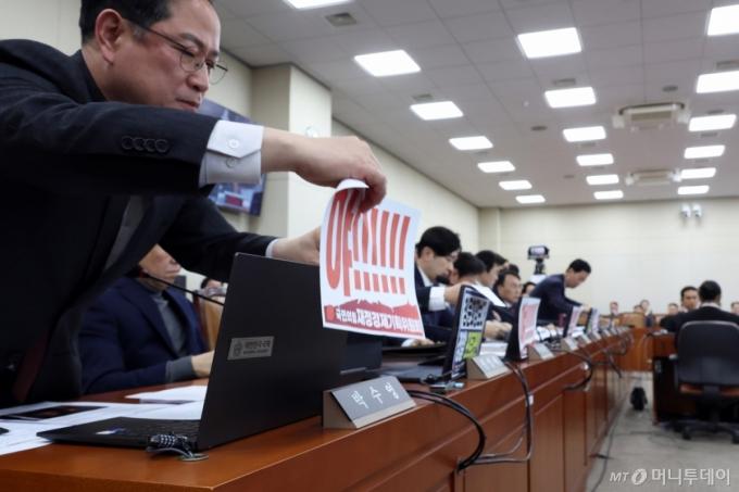 (서울=뉴스1) 국회사진기자단 = 국민의힘 의원들이 23일 서울 여의도 국회에서 열린 재정경제기획위원회의 이혜훈 기획예산처 장관 후보자에 대한 인사청문회에서 노트북에 붙였던 피켓을 떼고 있다. 2026.1.23/뉴스1  Copyright (C) 뉴스1. All rights reserved. 무단 전재 및 재배포,  AI학습 이용 금지. /사진=(서울=뉴스1) 국회사진기자단