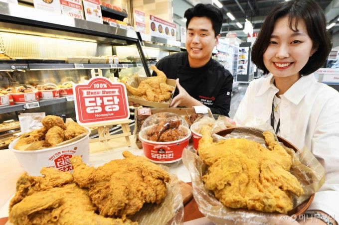 윤성민 홈플러스 델리사업팀 핫델리 담당 개발자(왼쪽)와 김태경 바이어가 29일 서울 '홈플러스 메가 푸드 마켓 라이브' 강서점에서 당당치킨 3주년을 기념해 '당당 3990옛날통닭'을 선보이고 있다. 홈플러스는 당당치킨 3주년을 맞아 다음달 3일부터 6일까지 '당당 3990옛날통닭'을 1마리 3990원에 판매한다. (홈플러스 제공. 재판매 및 DB 금지) 2025.6.29/뉴스1