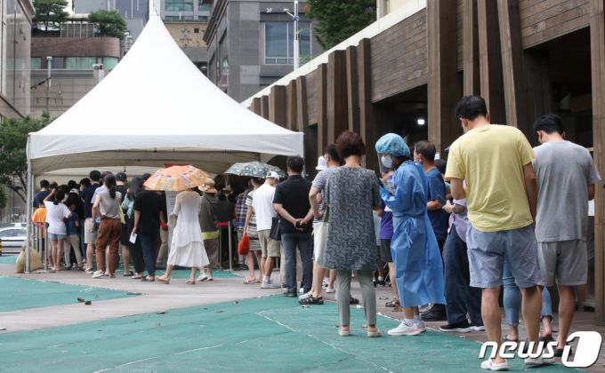 (서울=뉴스1) 송원영 기자 = 15일 서울 송파구보건소에 마련된 신종 코로나바이러스 감염증(코로나19) 선별진료소에서 시민들이 코로나19 검사를 받기 위해 길게 줄을 서 있다. 질병관리청 중앙방역대책본부는 이날 0시 기준 코로나19 신규 확진자가 6만 2078명이라고 밝혔다. 이로써 누적 확진자는 2141만 836명이 됐다. 2022.8.15/뉴스1  Copyright (C) 뉴스1. All rights reserved. 무단 전재 및 재배포 금지.