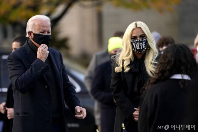 [피츠버그=AP/뉴시스]조 바이든(왼쪽) 미 민주당 대선 후보가 2일(현지시간) 펜실베이니아주 피츠버그의 한 광장에서 가수 레이디 가가와 함께 피츠버그대 학생들을 만나고 있다. 바이든 후보는 학생들에게 인사말을 건넨 후 레이디 가가를 가리키며 "이제 레이디 가가가 연설할 것이고, 나는 노래할 것"이라고 농담을 건네기도 했다. 2020.11.03.