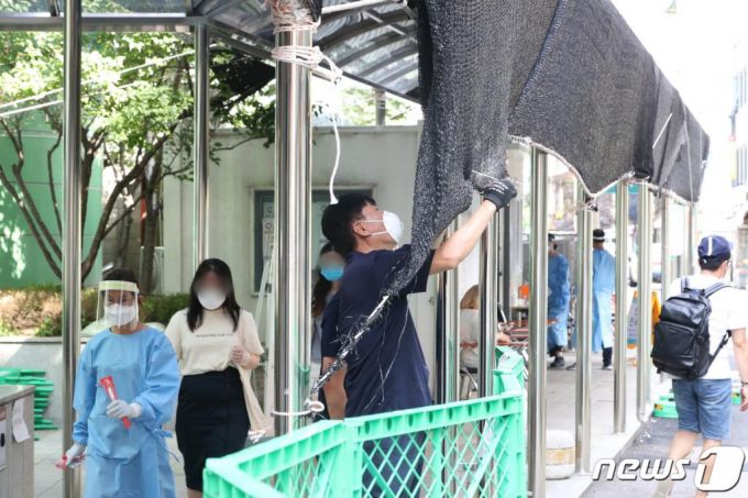 태풍 '바비'가 북상하고 있는 26일 서울 중구보건소 선별진료소에서 관계자들이 태풍 피해에 대비해 천막을 고정하고 있다./사진=뉴스1