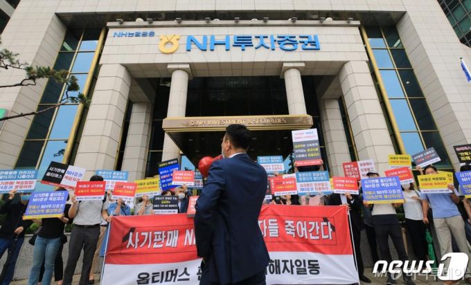 (서울=뉴스1) 구윤성 기자 = 옵티머스 펀드 NH투자증권 피해자들이 23일 오전 서울 여의도 NH투자증권 앞에서 '사기판매'를 규탄하고 있다. 옵티머스펀드의 최대 판매사인 NH투자증권은 이날 이사회를 열고 환매가 중단된 옵티머스자산운용 사모펀드 투자자들에 대한 유동성 공급 방안을 논의할 것으로 알려졌다. 2020.7.23/뉴스1