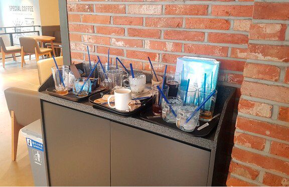 수북이 쌓여있는 다회용 컵들. 컵을 닦을 직원이 없어 일회용 컵에 음료를 주고 있다.