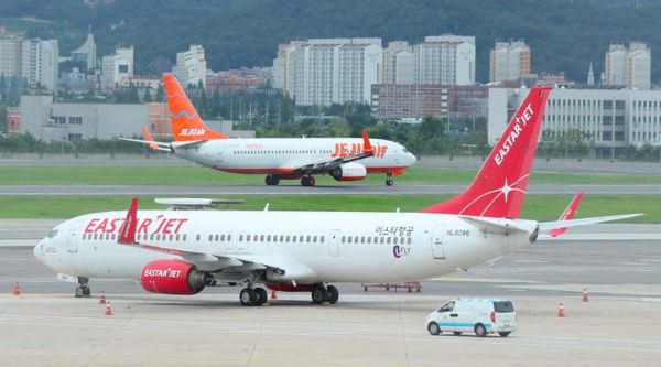24일 오후 서울 김포공항 주기장에 세워진 이스타항공 여객기 뒤로 제주항공 여객기가 이륙하고 있다. /연합뉴스