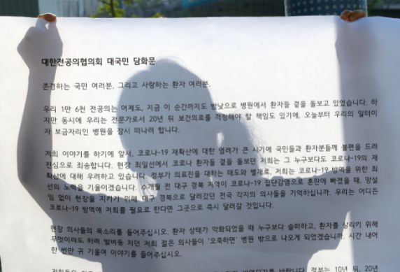 24일 오전 서울 흑석역 앞에서 중앙대병원 의과대학 학생협회-인턴, 젊은의사단체행동 회원이 전공의협의회 담화문을 들고 있다./연합뉴스