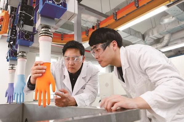 금호석유화학 연구원들이 NB라텍스를 사용한 의료용 장갑 제품을 연구하는 모습. / 금호석유화학 제공