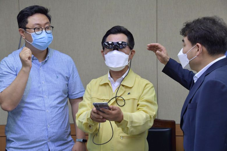 박정현 부여군수(가운데)가 오는 7월 부여 정림사지와 공주 공산성 체험존에 마련될 AR글래스 ‘U+리얼글래스’를 체험해 보는 모습. /LG유플러스 제공