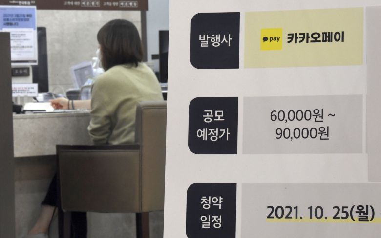 카카오페이 공모주 청약일인 지난 25일 서울 영등포구 여의도 한국투자증권 여의도본점 영업장에 설치된 카카오페이 청약 입간판 너머로 고객들이 상담을 받고 있다. / 연합뉴스