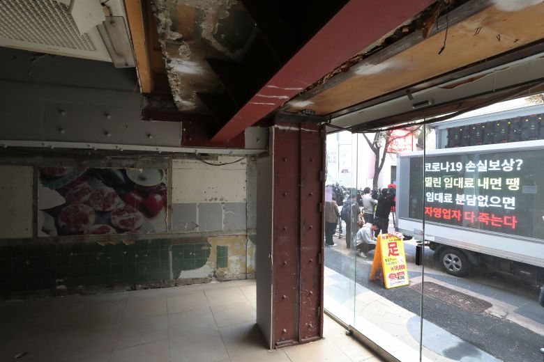 코로나19 불황 여파로 폐업한 한 상점 앞에서 자영업자와 시민단체 활동가들이 '코로나19 임대료를 멈춰라' 캠페인을 벌이고 있다. / 연합뉴스