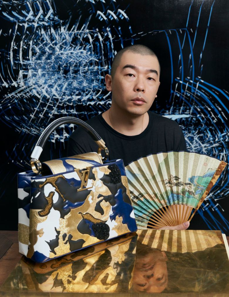 중국 예술가 자오자오(Zhao Zhao)가 루이비통과 협업해 만든 카퓌신(Capucines)백 뒤에서 포즈를 취하고 있다. /루이비통