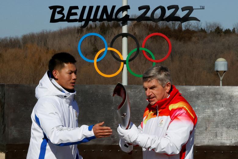 '2022 베이징동계올림픽' 개막일인 4일 성화 봉송 주자로 나선 토마스 바흐(오른쪽) 국제올림픽위원회(OC) 위원장이 중국 베이징의 올림픽 공원에서 성화를 넘겨받고 있다. /로이터 연합뉴스