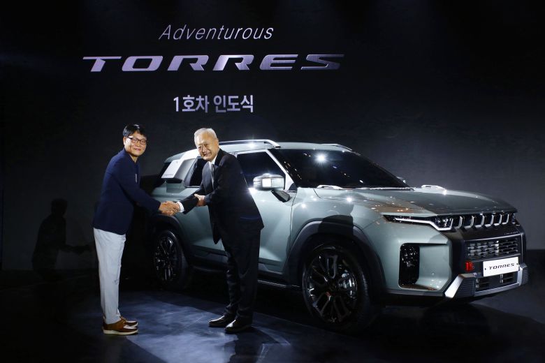 쌍용차는 최근 출시한 신차 '토레스' 1호차를 협력업체인 진영전기 김두영 회장(오른쪽)에게 전달했다. 그동안 고통을 분담해온 협력업체에 감사의 마음을 전한다는 의미였다./쌍용차 제공