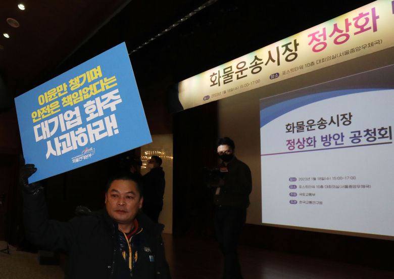 지난 18일 서울 중구 포스트타워에서 국토교통부 주최로 열린 화물운송시장 정상화 방안 공청회에 화물연대 노조원들이 손 피켓을 들고 참석하고 있다. /뉴스1