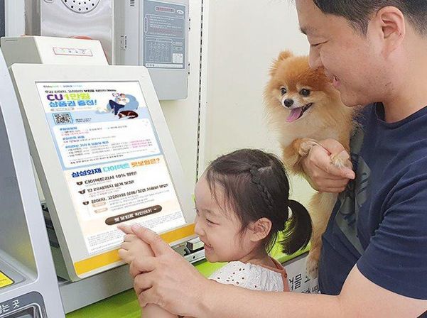 CU 편의점을 찾은 고객이 택배기기 스크린에 뜬 펫보험 설명을 보고 있다. /BGF리테일 제공